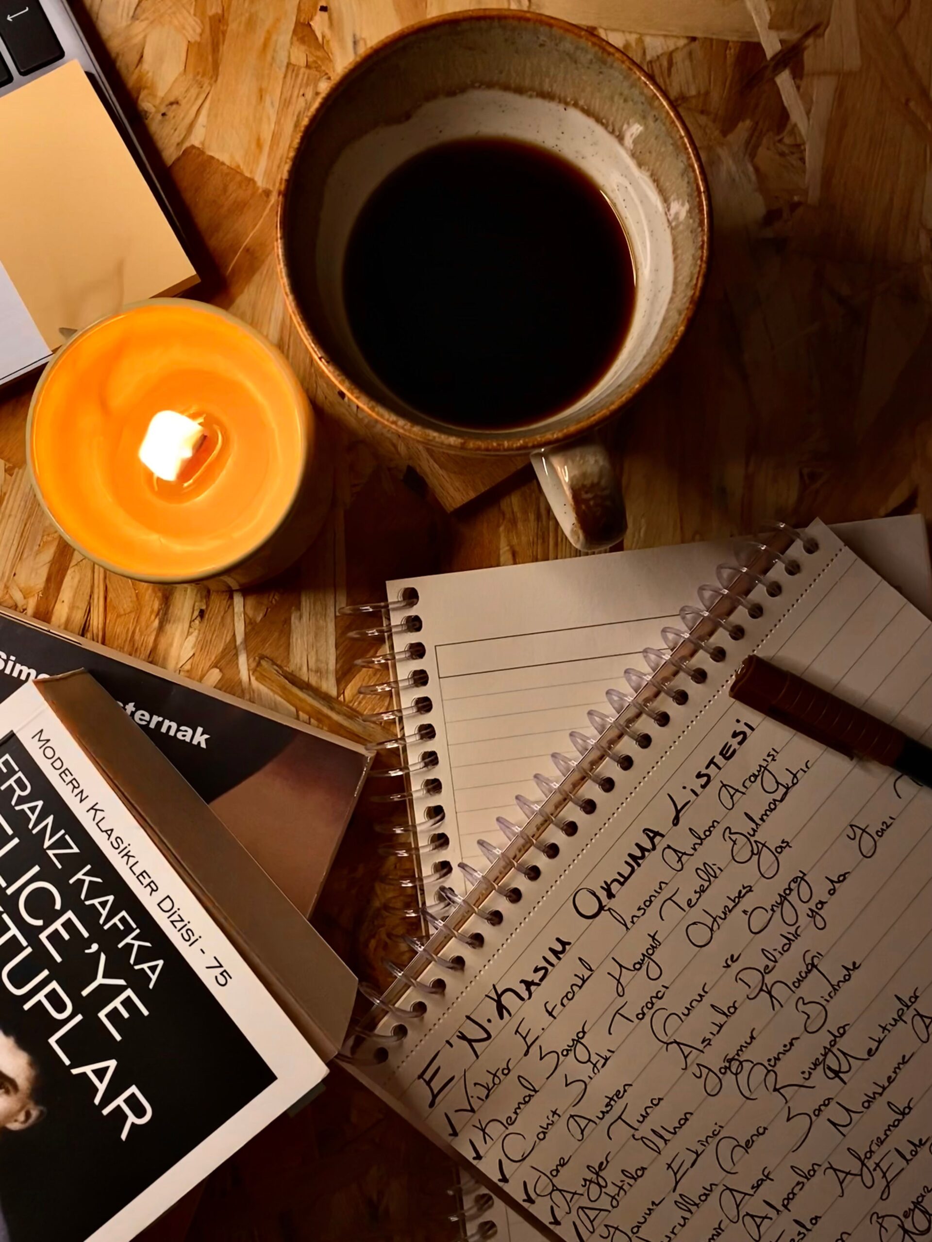 Warm workspace with coffee, books, and a handwritten note for a cozy atmosphere.