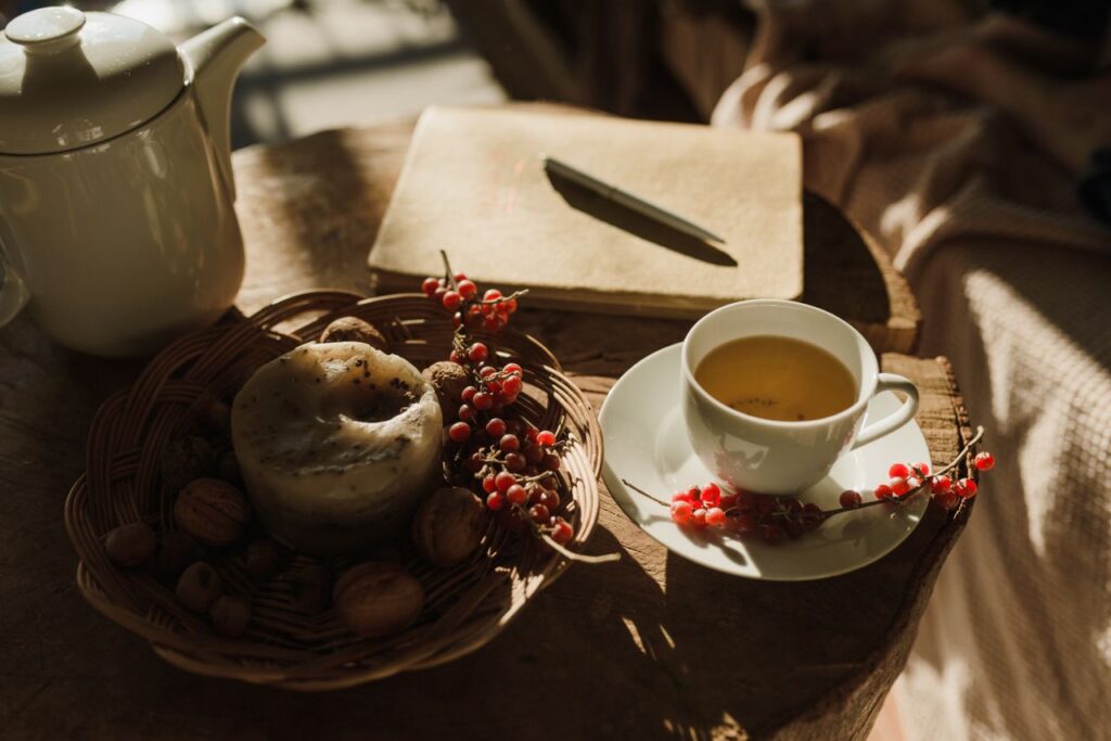 A warm cup of tea paired with nuts and candle for a cozy breakfast setting.